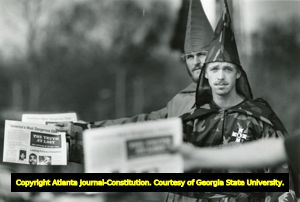 Two members of the Ku Klux Klan handing out extremist newspapers